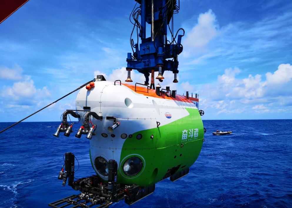 China's new deep-sea manned submersible Fendouzhe is being lowered into the water. [Photo provided to China Daily]